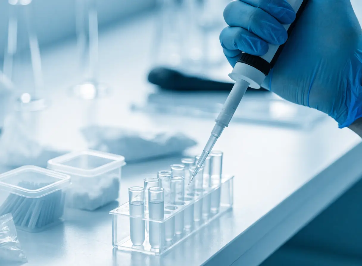 Laboratory technician pipetting samples into test tubes in a modern lab